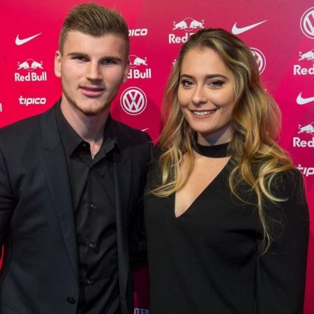 Timo Werner in a black suit poses for  a picture.